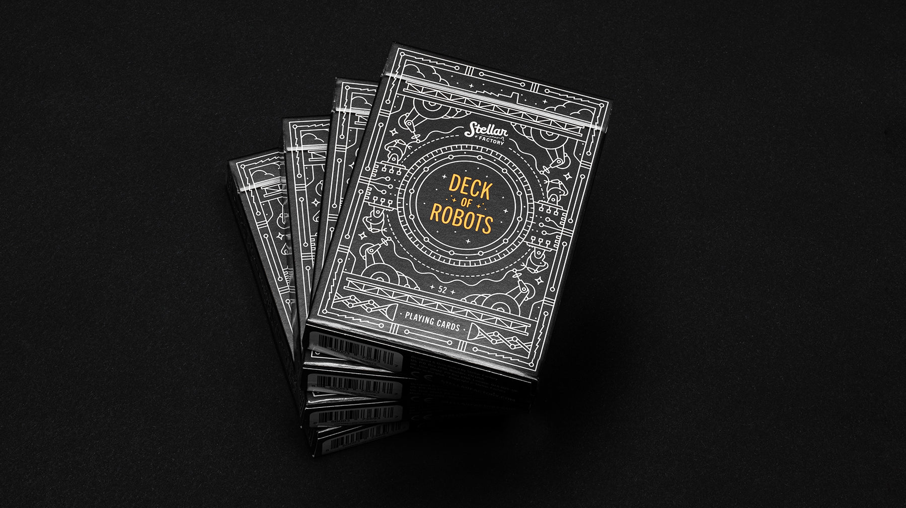 Ornate boxes of playing cards with 'Deck of Robots' and black and white geometric designs on a black background