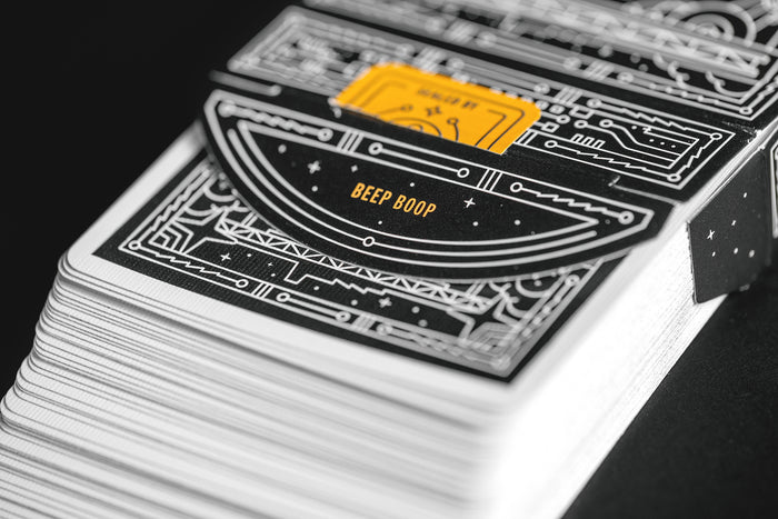close-up of a deck of playing cards with a unique robot-themed design on the back