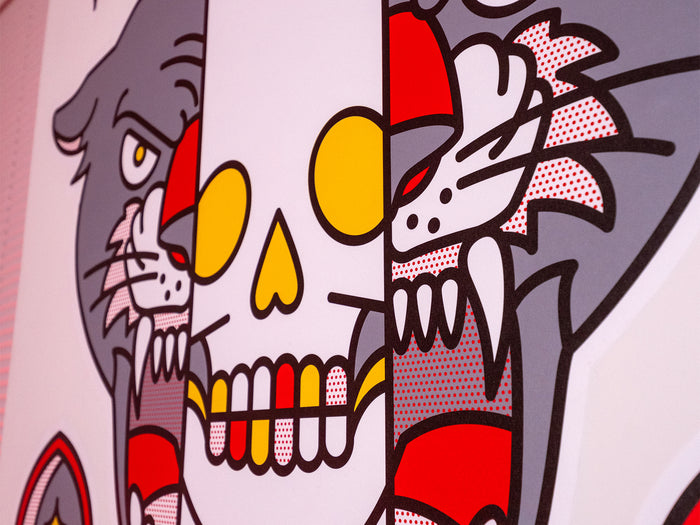 A close up of a wall graphic of a fierce cat and skull in red, yellow and grey
