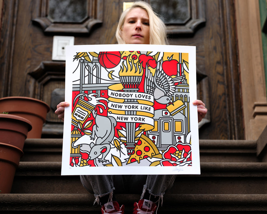 The artist Red Halftone holding a colorful limited edition screen print with New York-themed design against a on a stoop.