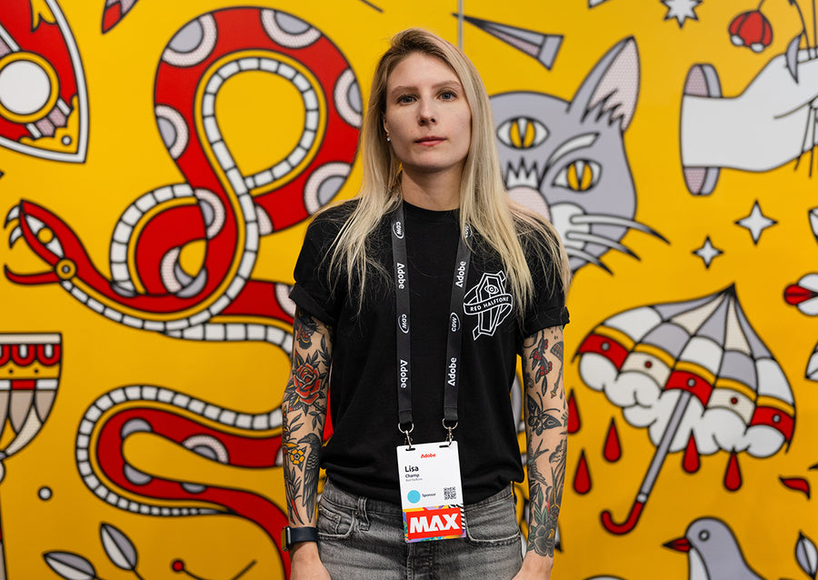 Lisa Champ of Red Halftone standing in front of a patterned red, yellow, grey and white wall at Adobe Max in Miami, FL.