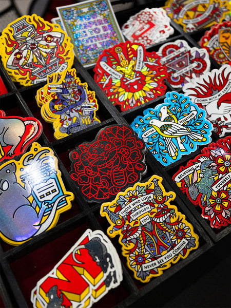 Collection of colorful die cut stickers in a black display.