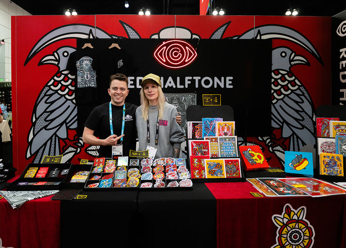 Red Halftone and assistant standing behind the booth displaying products at Adobe MAX 2026.