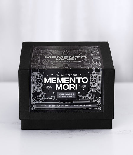 Memento Mori candle packaging with a black decorative label on a white background
