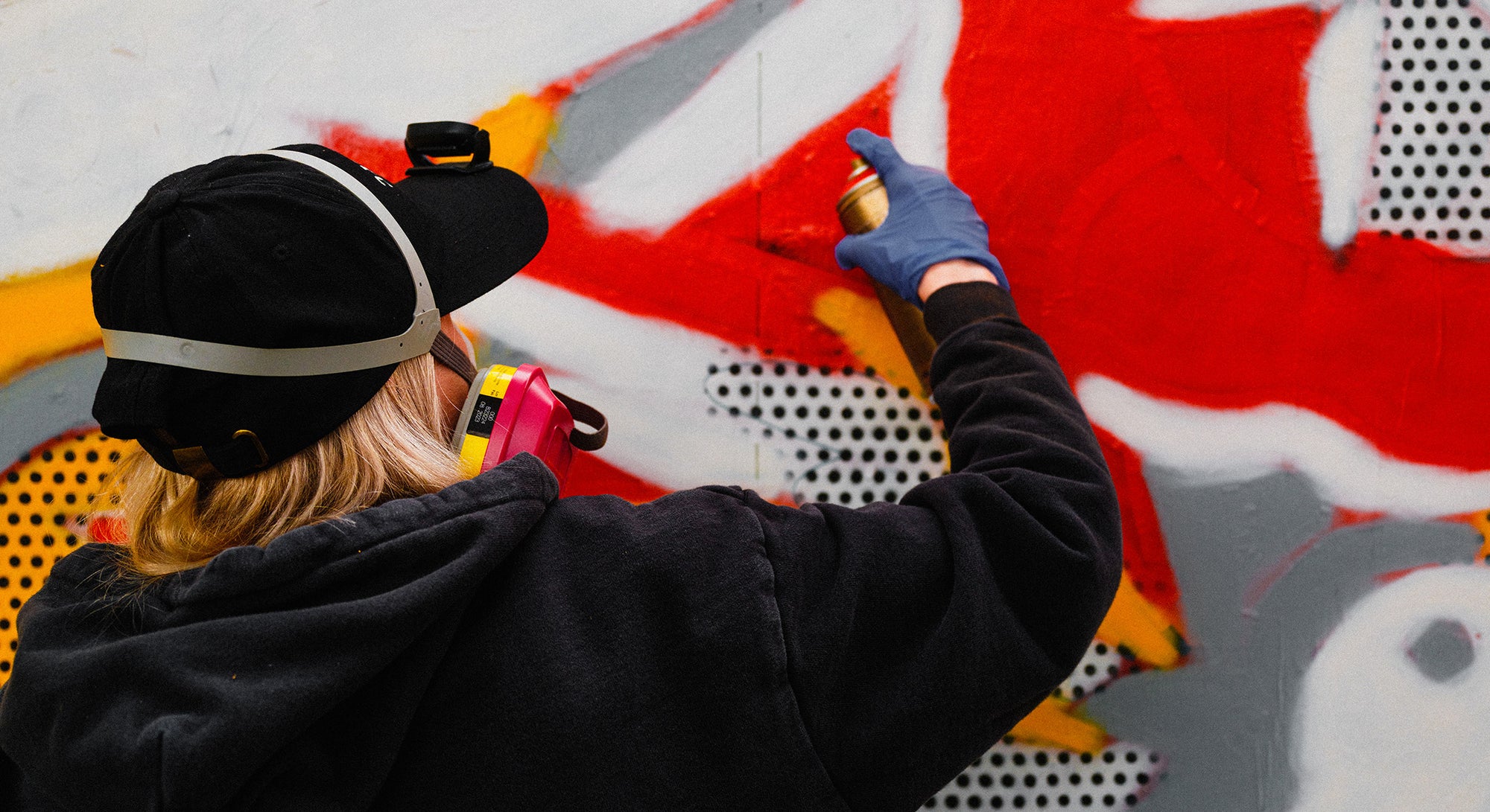 Artist Red Halftone painting a mural at East New York Walls