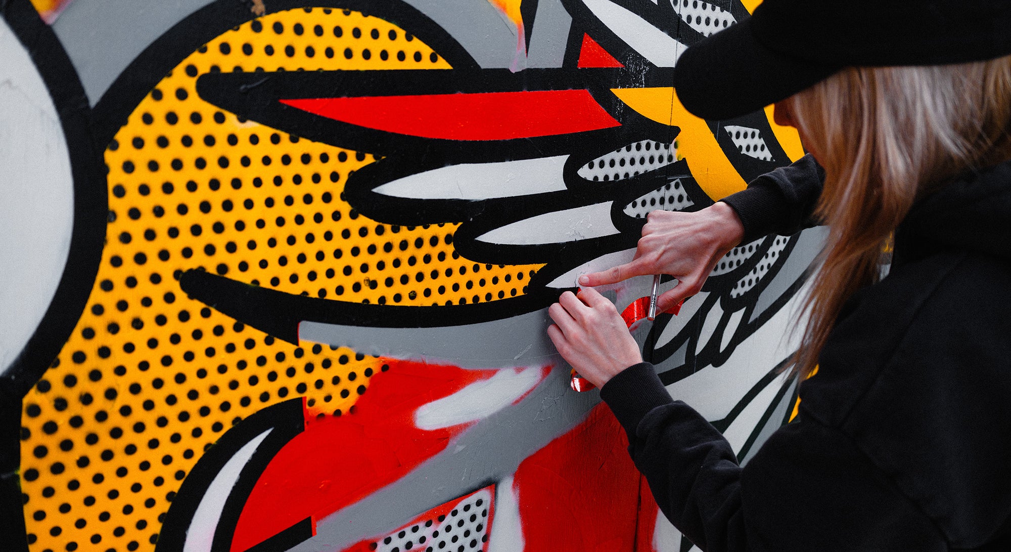 Artist Red Halftone removing vinyl stencil from wall