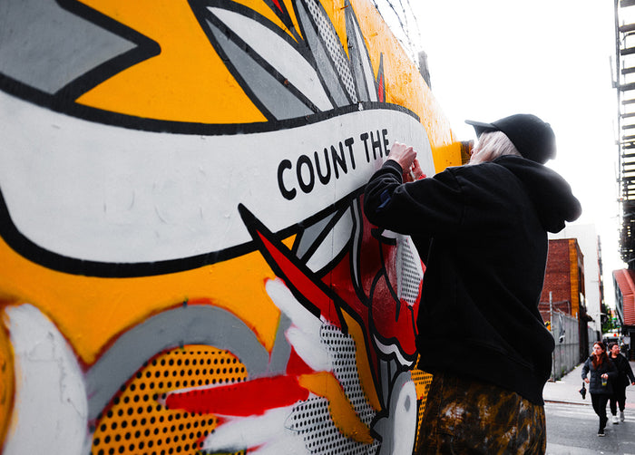 Artist Red Halftone removing vinyl stencil from wall