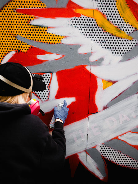Artist Red Halftone painting a mural at East New York Walls