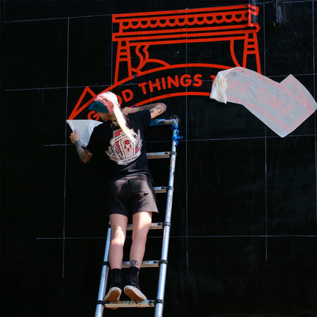 Lisa Champ of Red Halftone on a ladder with 'Good Things' vinyl in the background