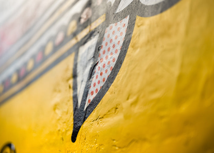Close-up of a mural by the artist Red Halftone showing a yellow surface with a black and white patterned design