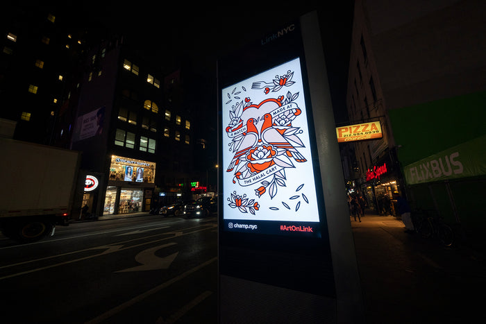 Digital kiosk in New York City featuring the artwork of the artist Red Halftone at night with illuminated signs in the background.