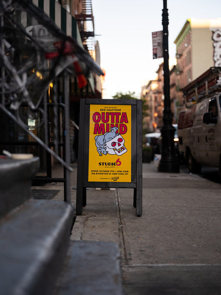 Outdoor A-frame sign with info for the "Outta Mind" exhibition in front of Studio6 Gallery.