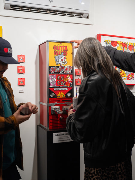 People interacting with a colorful Red Halftone-branded vending machine at Studio6 Gallery.
