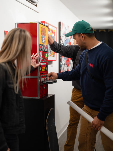 People interacting with a colorful Red Halftone-branded vending machine at Studio6 Gallery.