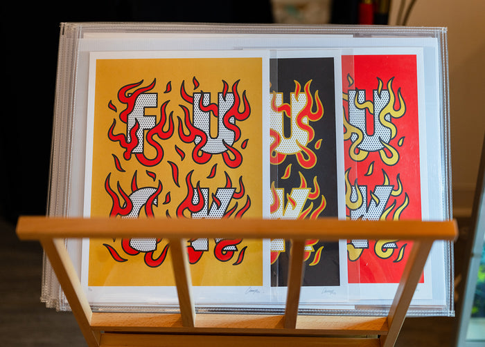 Limited edition prints by Red Halftone  with flame designs on a wooden stand