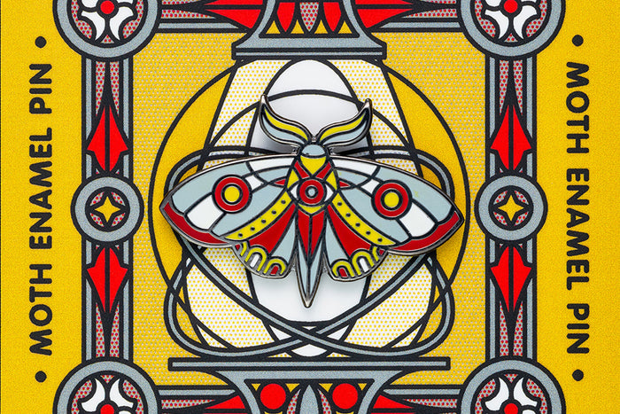 Moth enamel pin design on a yellow background with a decorative border