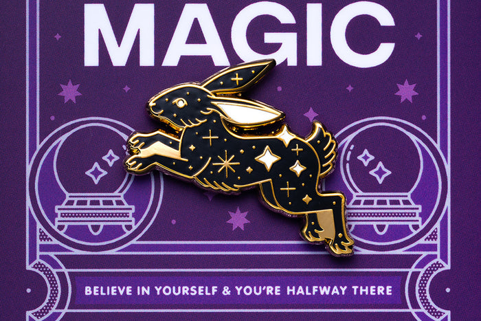 Gold and black rabbit pin on a purple background with 'MAGIC' and motivational text
