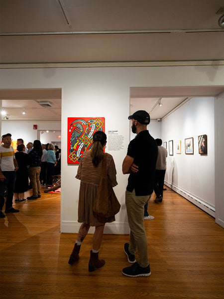 People in a gallery looking at art by Red Halftone on the wall