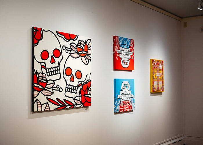 Four pieces of artwork by Red Halftone featuring skulls and abstract designs on a light-colored wall.