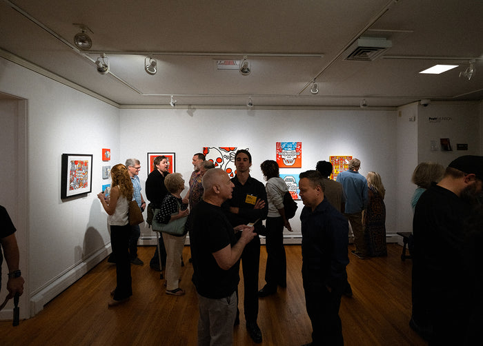 Group of people in Pratt Munson gallery viewing artwork by Red Halftone on the walls.