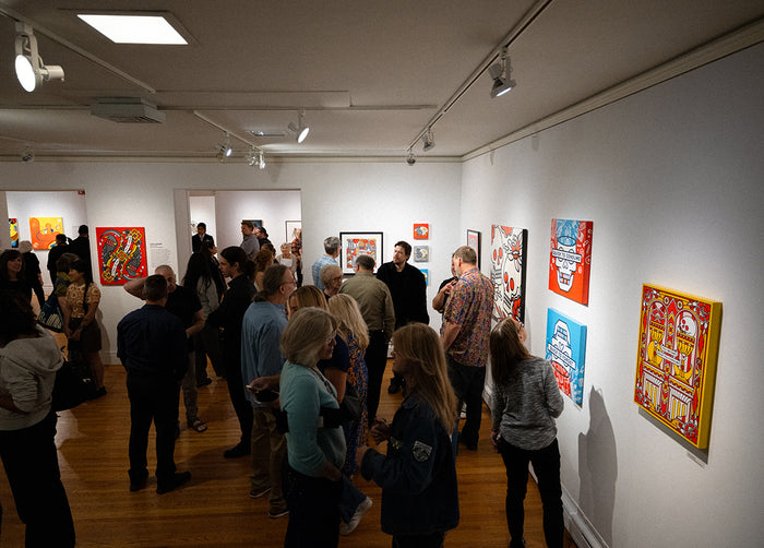 Group of people in Pratt Munson gallery viewing artwork by Red Halftone on the walls.