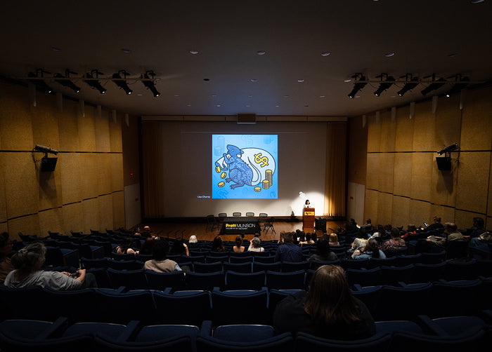 A screen displaying art by Red Halftone in an auditorium at Patt Munson College of Art and Design