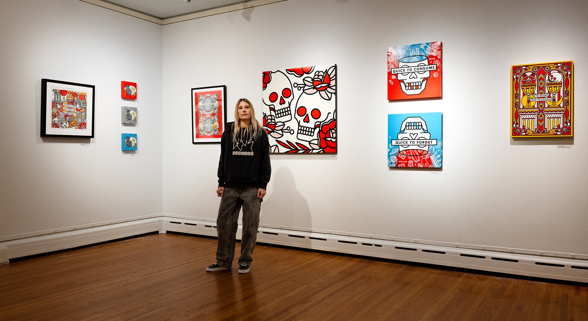 Lisa Champ standing in front of her art on the wall at Pratt Munson gallery 